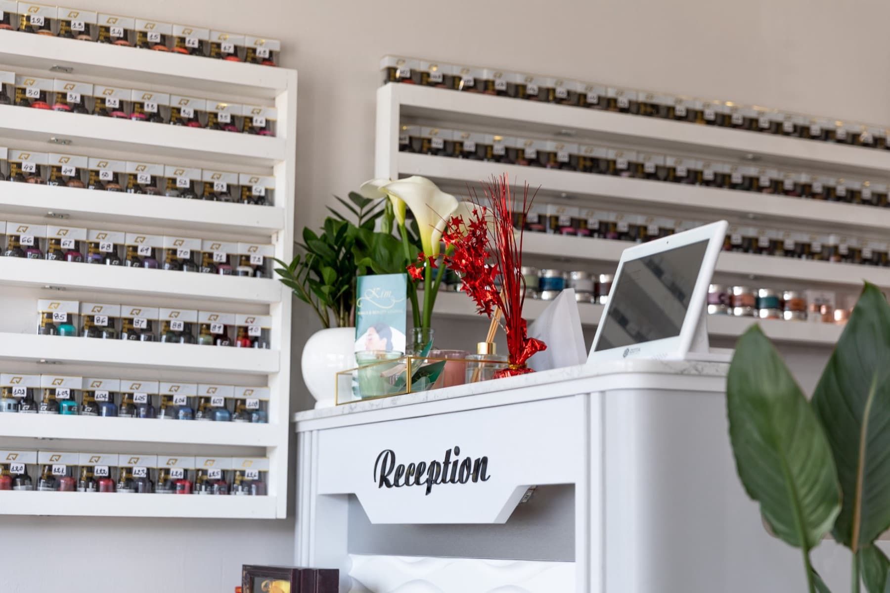 The reception desk in front of the salon's wall of gel colors